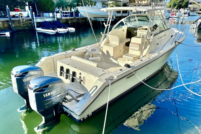 Slide: The Image of 2004 Pursuit 3070 Offshore boat with twin Yamaha engines docked in a marina. - 6