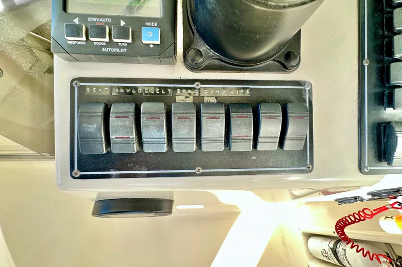 Slide: The Image of Control panel of a 2004 Pursuit 3070 Offshore boat with labeled switches. - 61