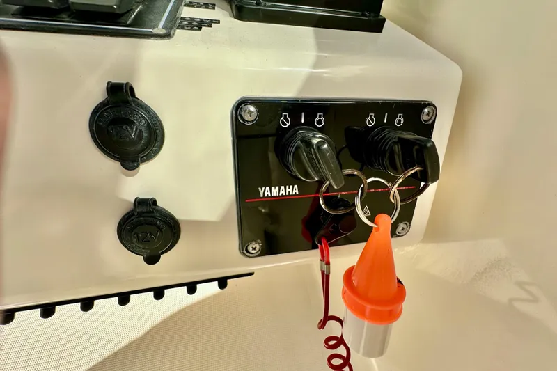 Slide: The Image of Control panel of a 2004 Pursuit 3070 Offshore boat with Yamaha ignition keys. - 62