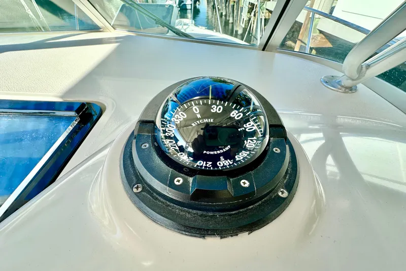 Slide: The Image of Compass on 2004 Pursuit 3070 Offshore boat dashboard, reflecting sunlight. - 63