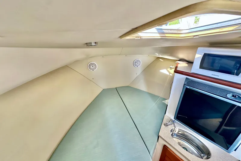 Slide: The Image of Interior of 2004 Pursuit 3070 Offshore boat with kitchenette and seating area. - 72