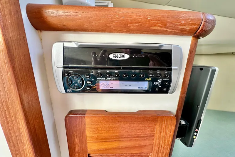 Slide: The Image of Clarion stereo system on 2004 Pursuit 3070 Offshore boat, mounted in wooden panel. - 79