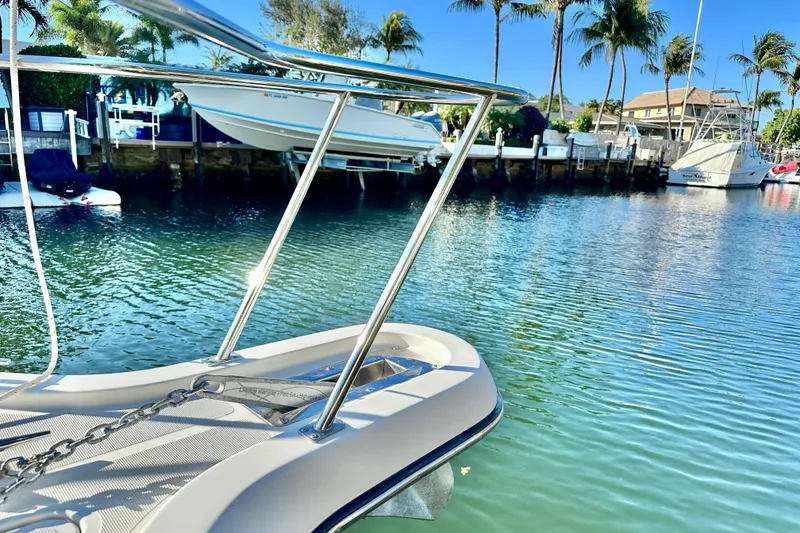 Slide: The Image of 2004 Pursuit 3070 Offshore boat docked in a serene marina with palm trees. - 8
