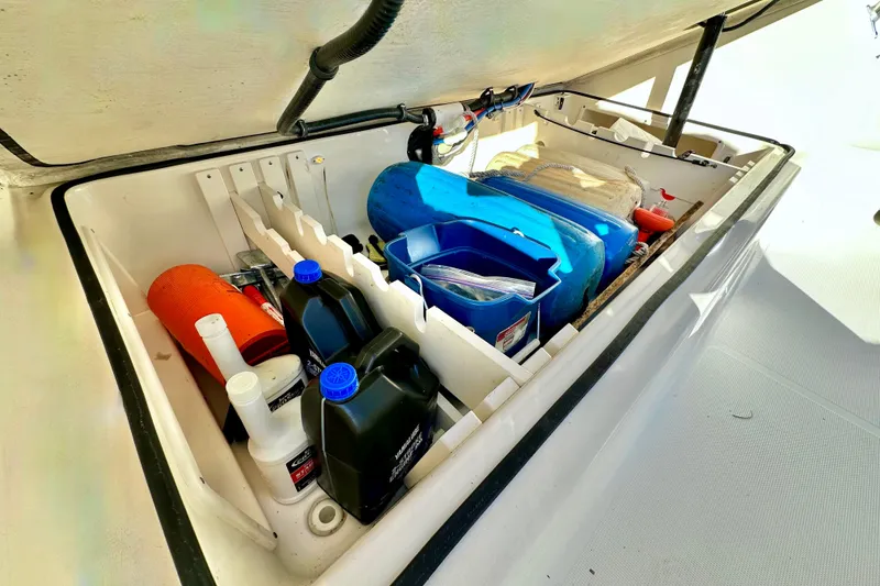 Slide: The Image of Storage compartment of a 2004 Pursuit 3070 Offshore boat with various supplies and equipment. - 82