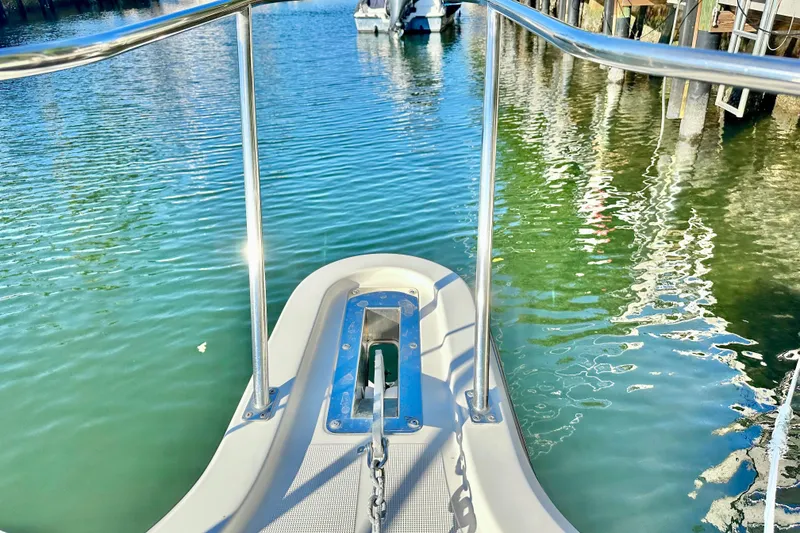 Slide: The Image of Bow view of 2004 Pursuit 3070 Offshore boat docked in calm waters. - 9