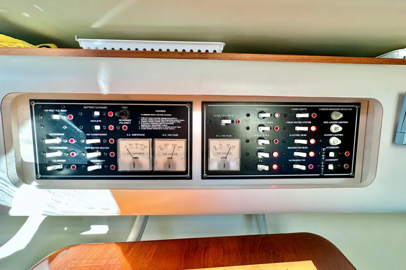 Slide: The Image of Control panel of a 2004 Pursuit 3070 Offshore boat with various switches and gauges. - 92