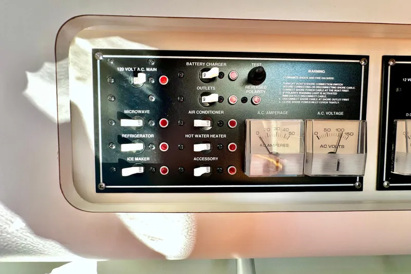 Slide: The Image of Electrical control panel of a 2004 Pursuit 3070 Offshore boat, featuring various switches and gauges. - 93