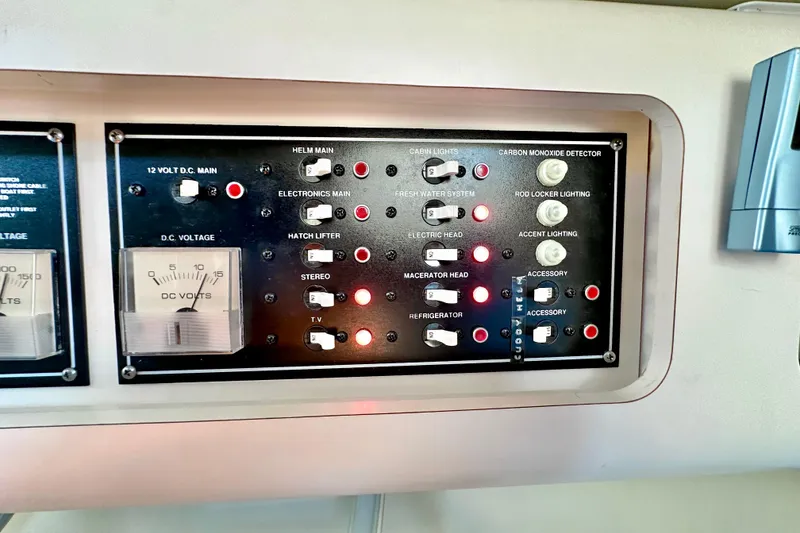 Slide: The Image of Control panel of a 2004 Pursuit 3070 Offshore boat with various switches and indicators. - 94