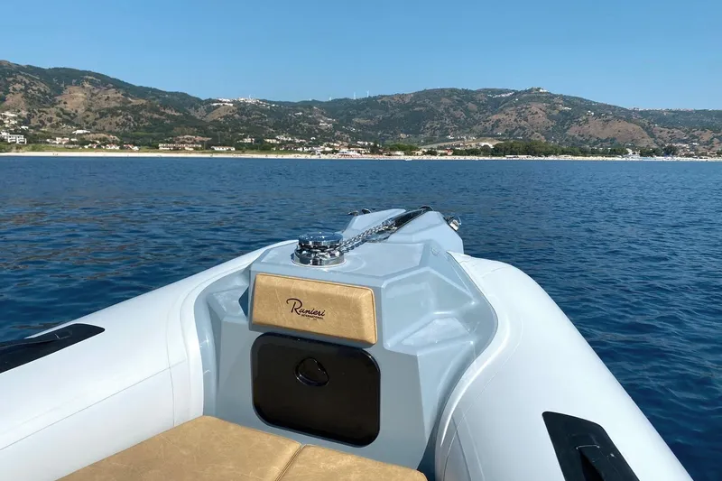 Slide: The Image of 2026 Ranieri Cayman 26.0 Sport boat on calm sea with scenic coastal backdrop. - 13