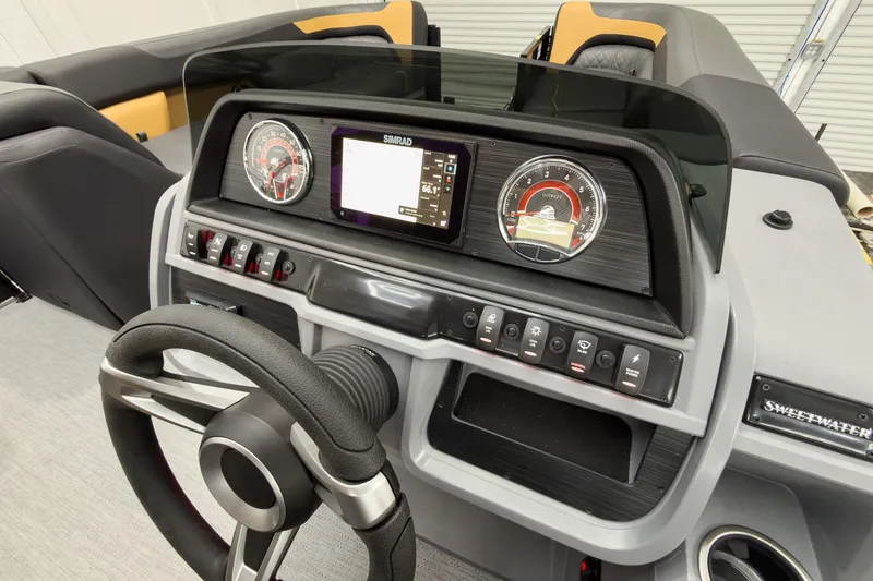 Slide: The Image of 2026 Godfrey Sweetwater 22' Tritoon dashboard with steering wheel and control panel. - 23
