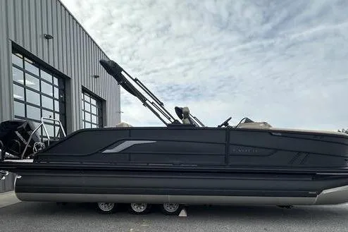 Slide: The Image of 2026 Evotti 723CS pontoon boat parked outside a modern building under a cloudy sky. - 5