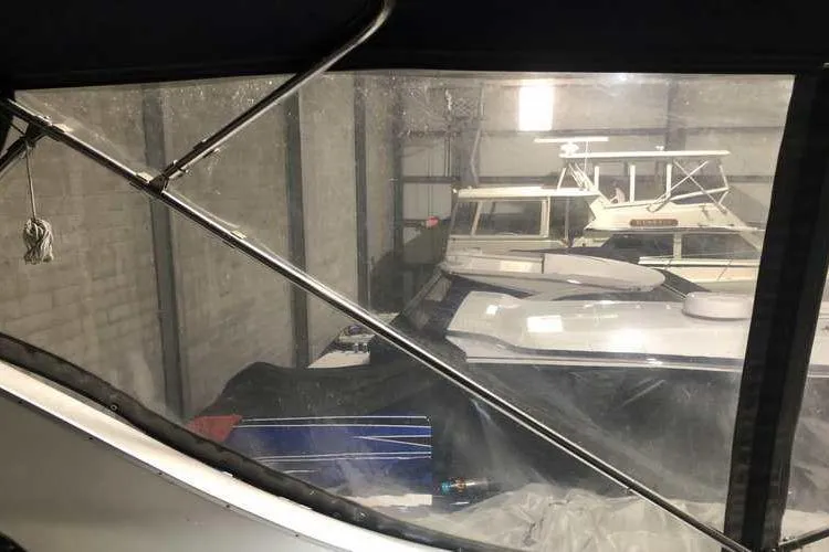 Slide: The Image of 1997 Bayliner 3988 Motoryacht stored indoors, partially covered, with other boats visible. - 18