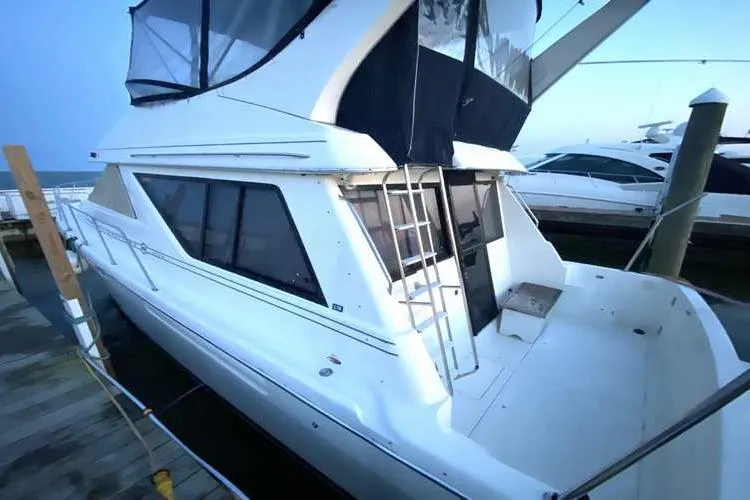 Slide: The Image of 1997 Bayliner 3988 Motoryacht docked, featuring spacious deck and sleek design. - 2