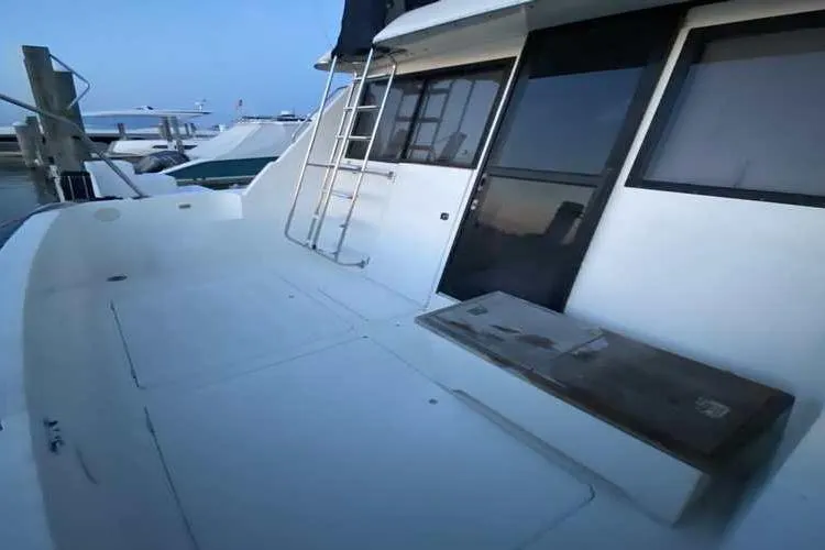 Slide: The Image of 1997 Bayliner 3988 Motoryacht deck with ladder and seating area at marina. - 3