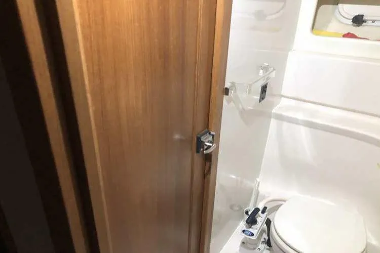 Slide: The Image of 1997 Bayliner 3988 Motoryacht bathroom with wooden door and compact toilet. - 52