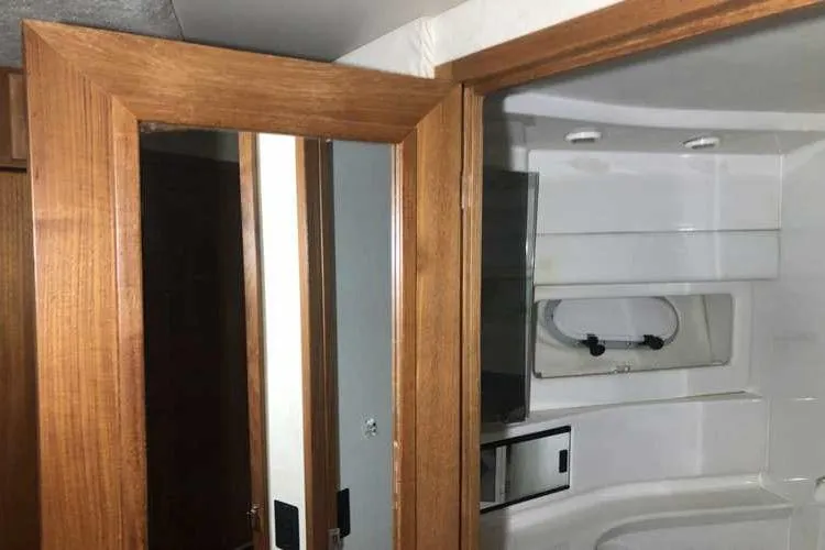 Slide: The Image of Interior of 1997 Bayliner 3988 Motoryacht bathroom with wooden door and white fixtures. - 60