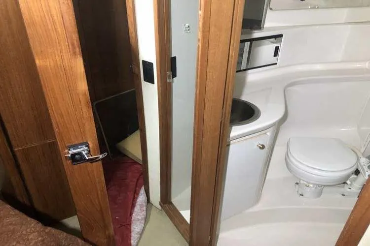 Slide: The Image of 1997 Bayliner 3988 Motoryacht bathroom with wooden doors, compact sink, and toilet. - 61