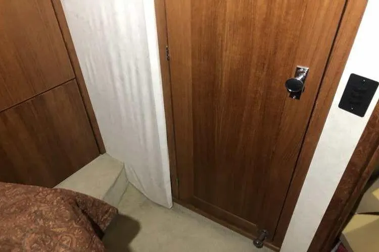 Slide: The Image of Interior of 1997 Bayliner 3988 Motoryacht with wooden door and carpeted floor. - 64