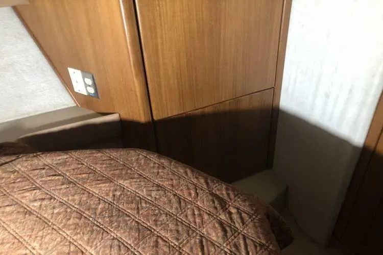 Slide: The Image of 1997 Bayliner 3988 Motoryacht interior cabin with wood paneling and quilted bedding. - 67