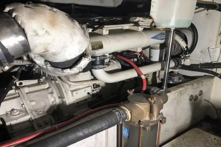 Slide: The Image of Engine room of 1997 Bayliner 3988 Motoryacht, showcasing mechanical components and piping. - 76