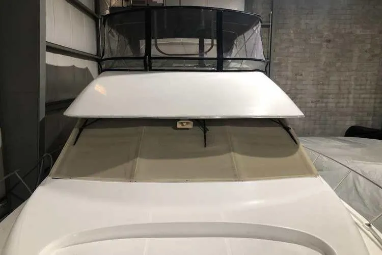 Slide: The Image of 1997 Bayliner 3988 Motoryacht in storage, showcasing upper deck and covered windows. - 8