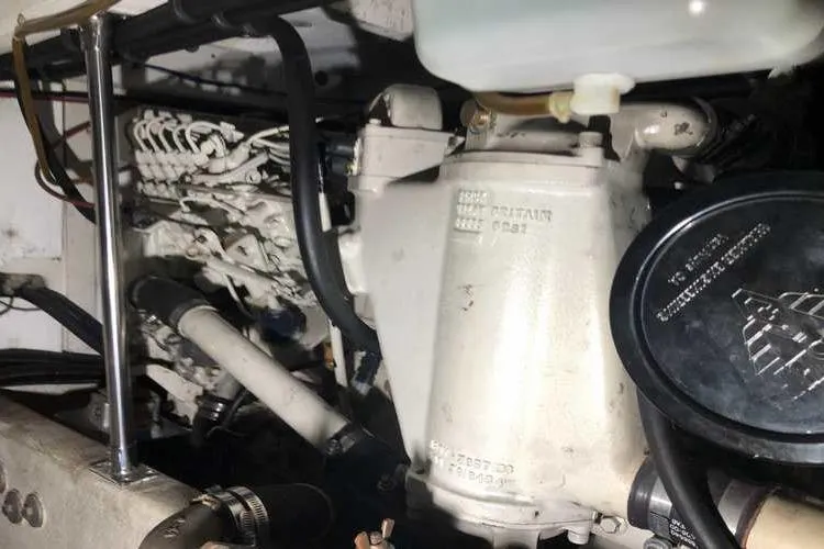 Slide: The Image of Engine compartment of 1997 Bayliner 3988 Motoryacht, showcasing mechanical components and hoses. - 81