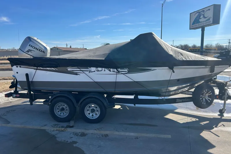 Slide: The Image of 2013 Lund 1800 Sport Angler boat with cover on trailer, featuring Honda outboard motor. - 10