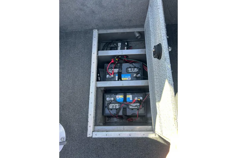 Slide: The Image of 2013 Lund 1800 Sport Angler battery compartment with multiple batteries and wiring. - 14