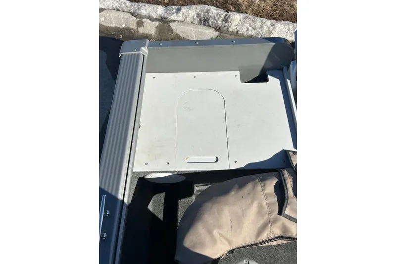 Slide: The Image of 2013 Lund 1800 Sport Angler boat interior with storage compartment and carpeted flooring. - 21