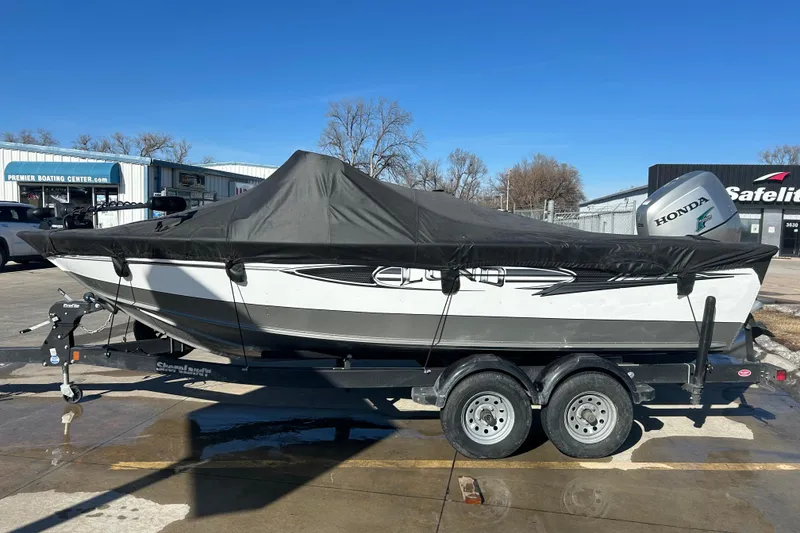 Slide: The Image of 2013 Lund 1800 Sport Angler boat on trailer with cover, parked outdoors. - 8
