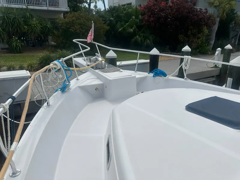 Slide: The Image of 1999 Mainship 430 Trawler bow with ropes and American flag at dock. - 12
