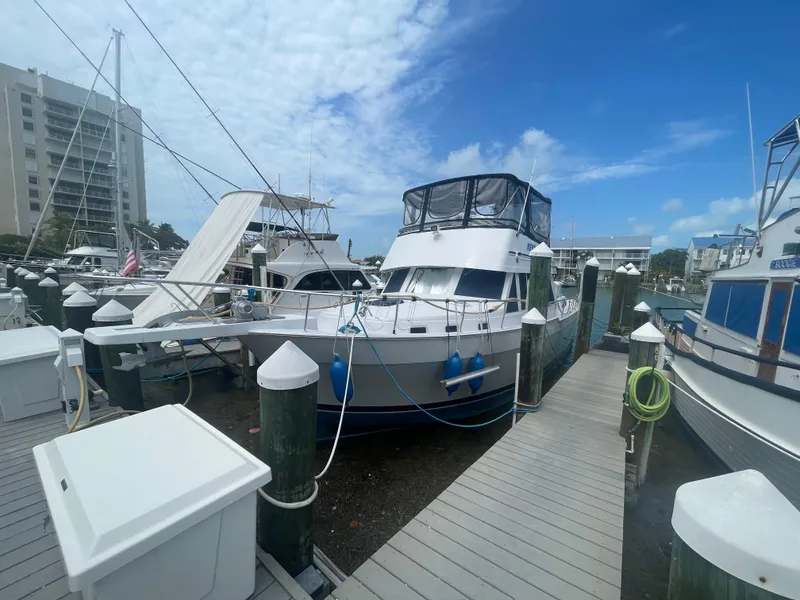 Slide: The Image of 1999 Mainship 430 Trawler docked at marina under blue sky. - 2