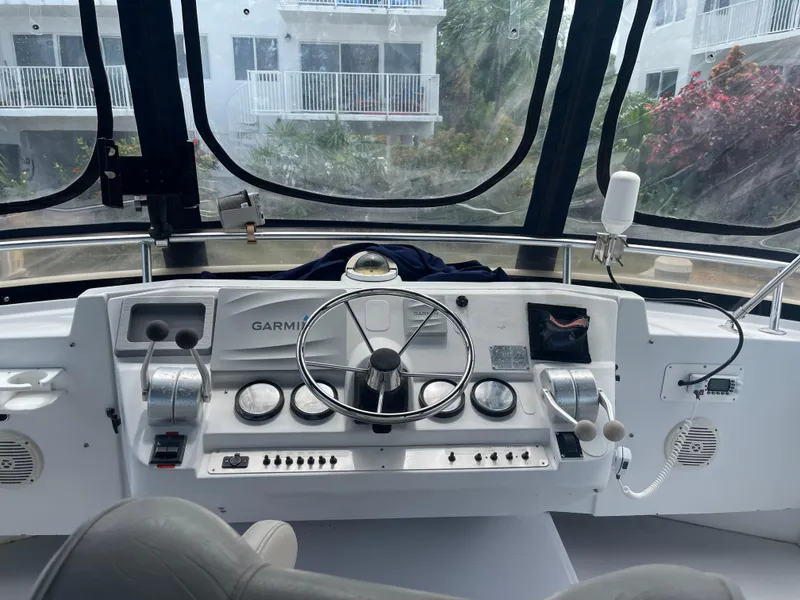 Slide: The Image of 1999 Mainship 430 Trawler helm with Garmin navigation, steering wheel, and control panel. - 31