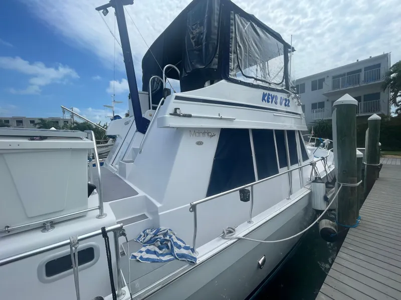 Slide: The Image of 1999 Mainship 430 Trawler docked at marina under blue sky. - 34