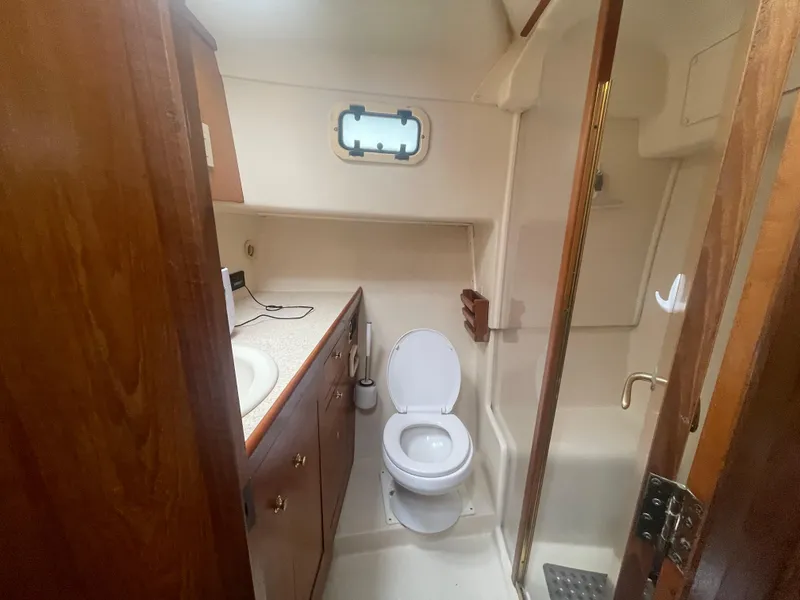 Slide: The Image of Bathroom interior of 1999 Mainship 430 Trawler with sink, toilet, and shower. - 38