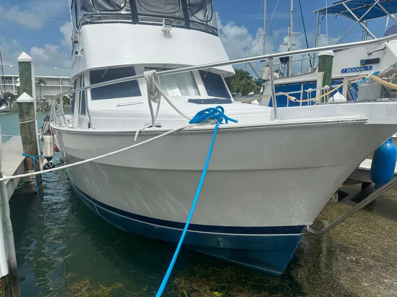 Slide: The Image of 1999 Mainship 430 Trawler docked at marina, clear sky background. - 4