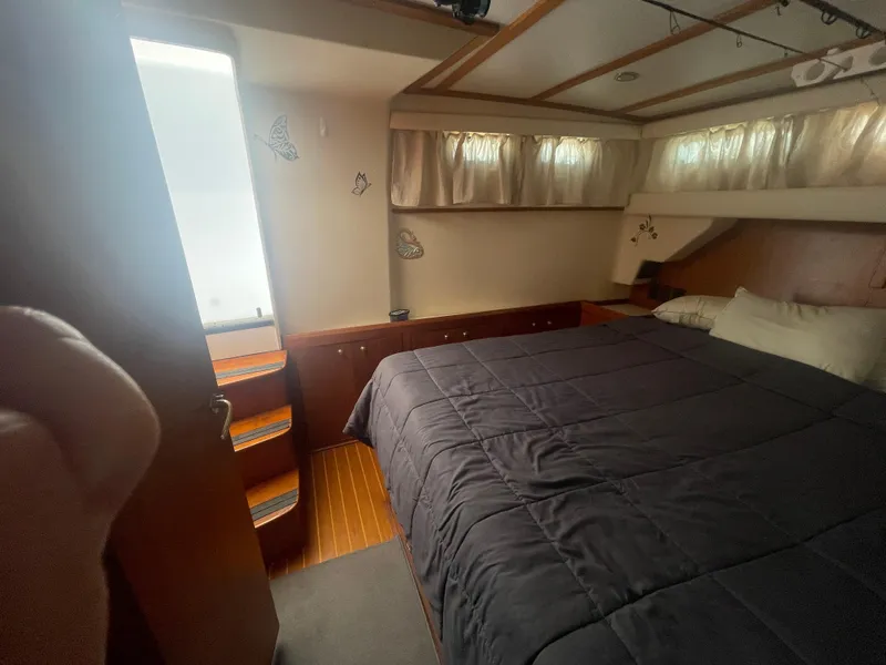 Slide: The Image of Cozy bedroom in 1999 Mainship 430 Trawler with natural light and wood accents. - 42