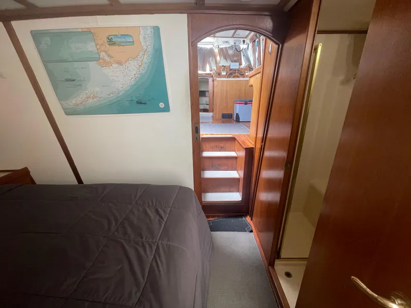 Slide: The Image of Interior of 1999 Mainship 430 Trawler with bed, map, and wooden stairs. - 43