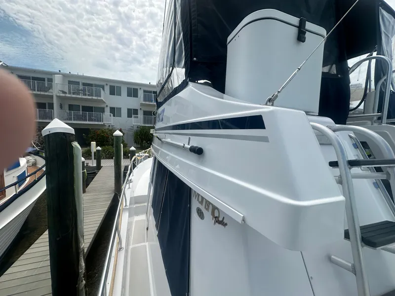 Slide: The Image of 1999 Mainship 430 Trawler docked, showcasing sleek design and modern features. - 8