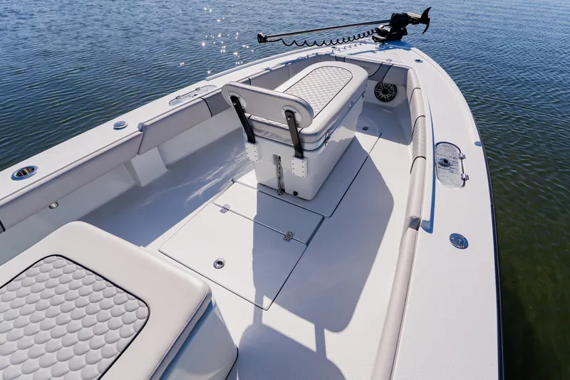 Slide: The Image of 2024 Dorado 25 boat interior with seating and storage, on calm water. - 24