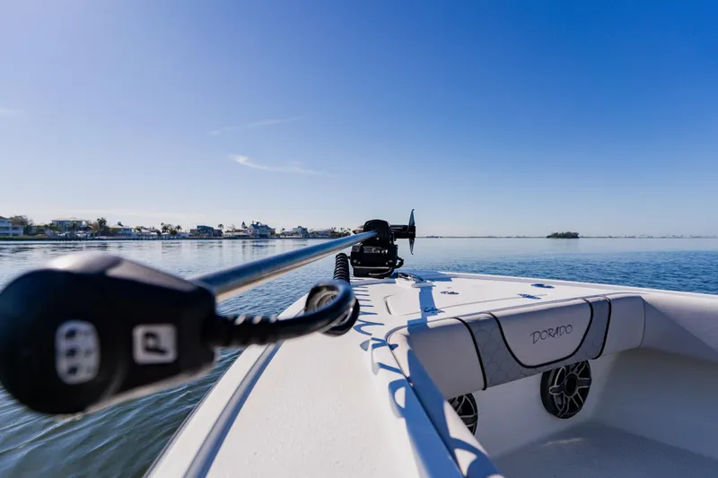 Slide: The Image of 2024 Dorado 25 boat on calm water under clear blue sky. - 27