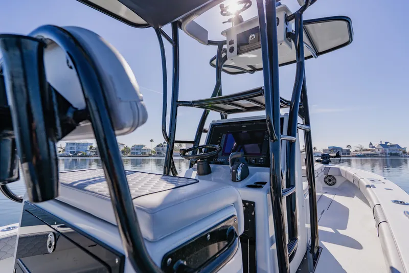 Slide: The Image of 2024 Dorado 25 boat interior with modern helm and seating on calm water. - 30