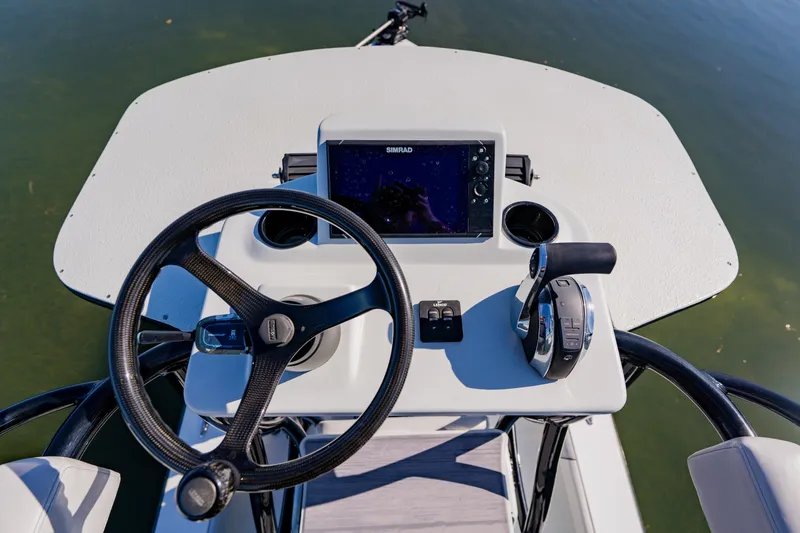 Slide: The Image of 2024 Dorado 25 boat helm with steering wheel, control panel, and navigation display. - 33