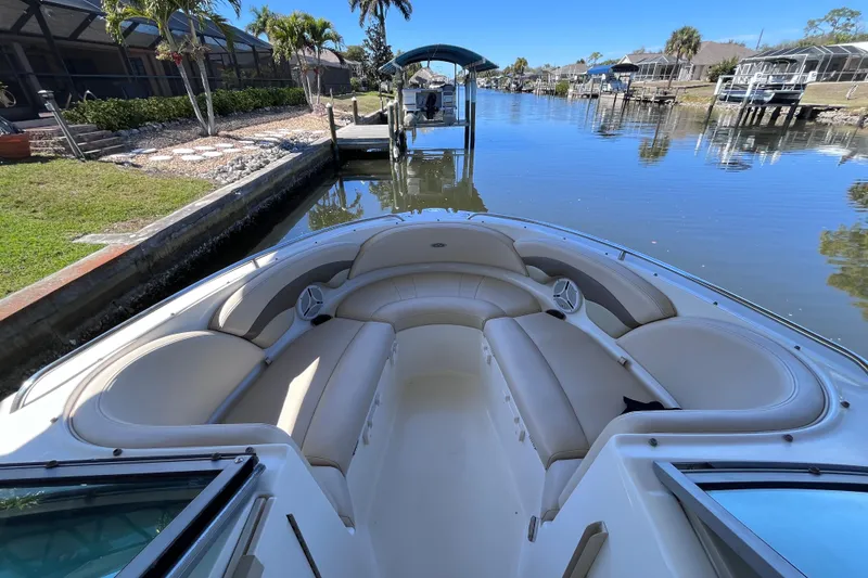 Slide: The Image of 2006 Chaparral 246 SSi boat with spacious seating, docked in a serene canal setting. - 16