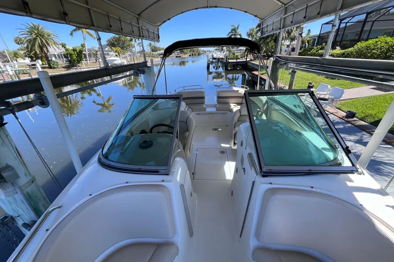Slide: The Image of 2006 Chaparral 246 SSi boat docked under canopy, reflecting on calm water. - 20
