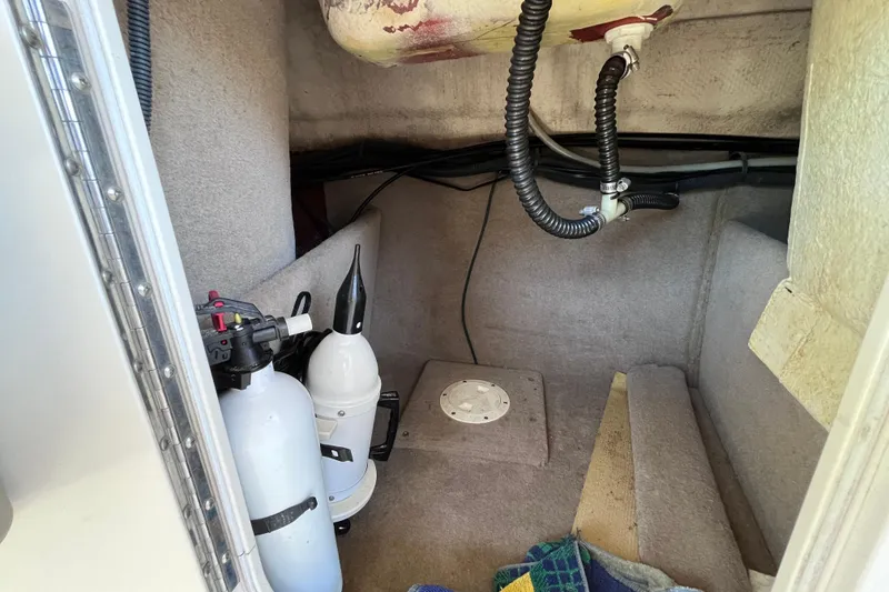 Slide: The Image of Interior of a 2006 Chaparral 246 SSi boat showing storage area with fire extinguishers. - 28