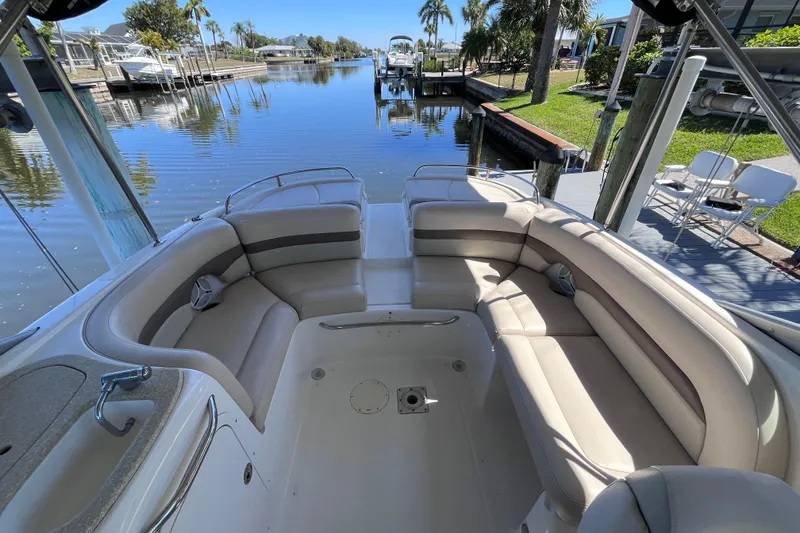 Slide: The Image of 2006 Chaparral 246 SSi boat interior with spacious seating by a serene waterfront. - 29