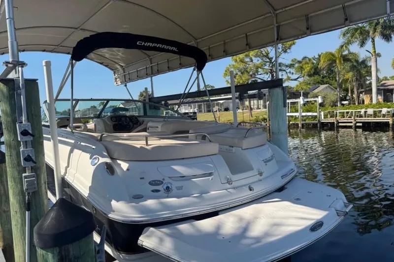 Slide: The Image of 2006 Chaparral 246 SSi boat docked under canopy, surrounded by water and greenery. - 3