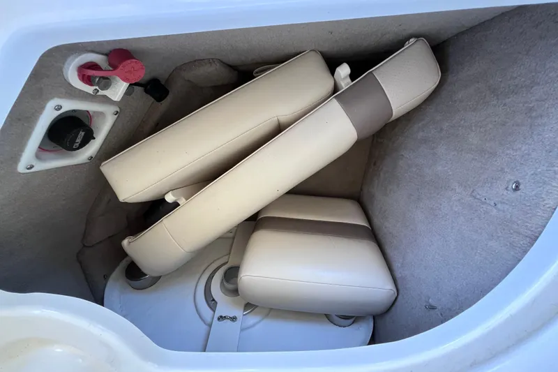 Slide: The Image of Storage compartment in a 2006 Chaparral 246 SSi boat with beige cushions. - 33