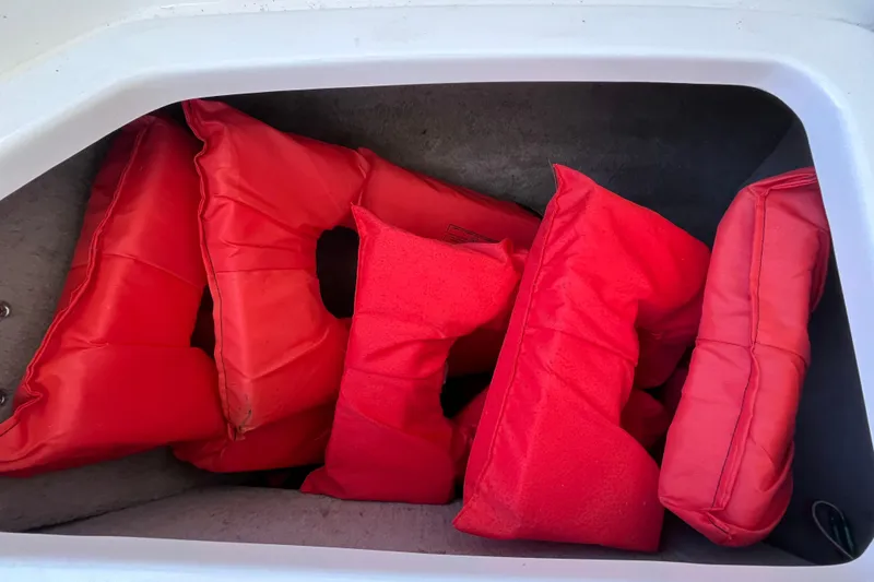 Slide: The Image of Red life jackets in storage compartment of a 2006 Chaparral 246 SSi boat. - 36